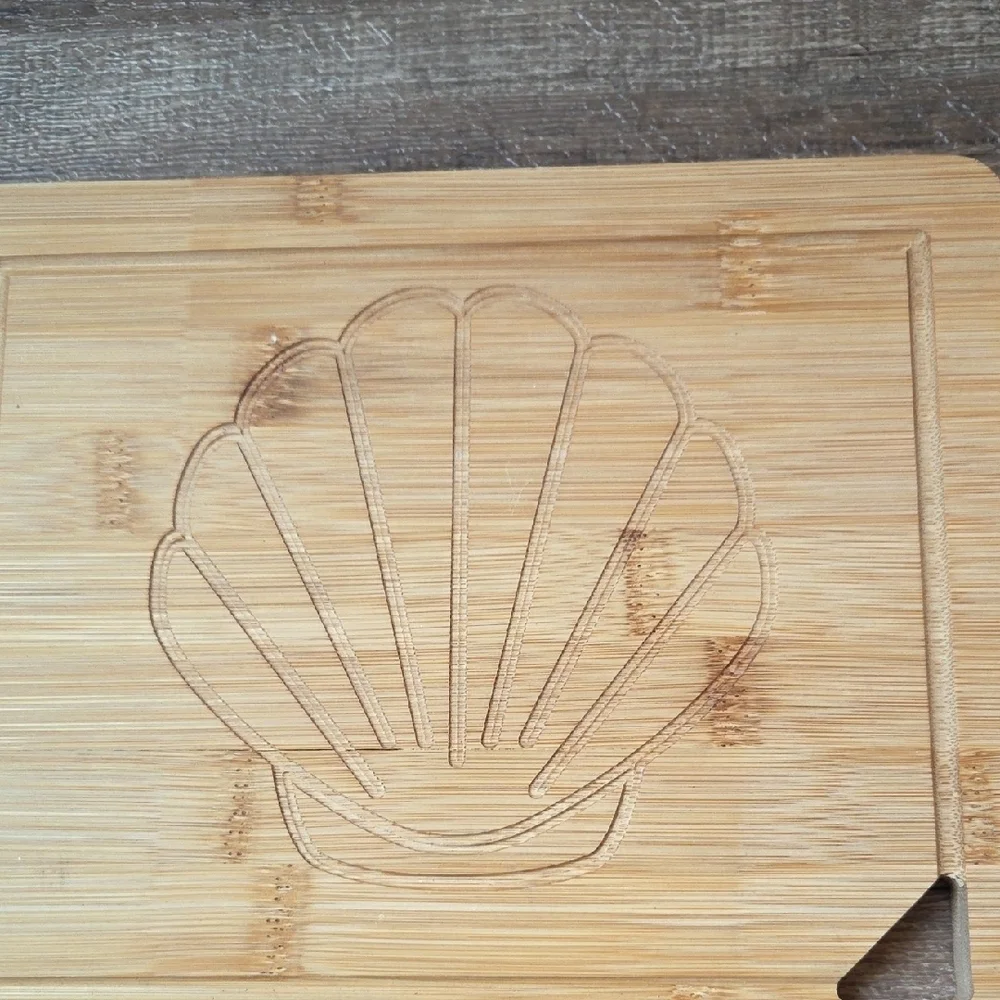 New Bamboo Cutting Board with Shell Design Carved In It